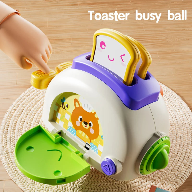 A white toaster busy ball sensory toy with a yellow handle and a smiling face, resting on a woven mat.