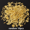 A pile of random gold metal charms and findings for DIY jewelry making