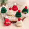 A set of mini knitted hats and scarves for dolls featuring red, green, and white colors with gold accents.
