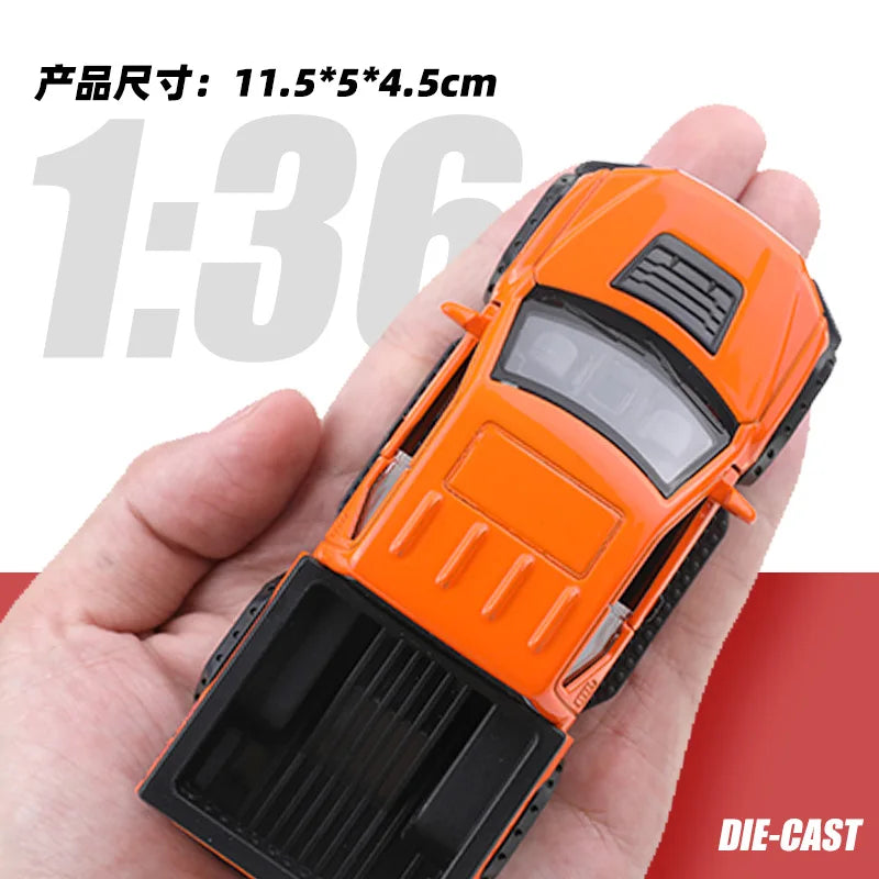 Orange 1:36 scale die-cast model of an off-road pickup truck being held in a hand.