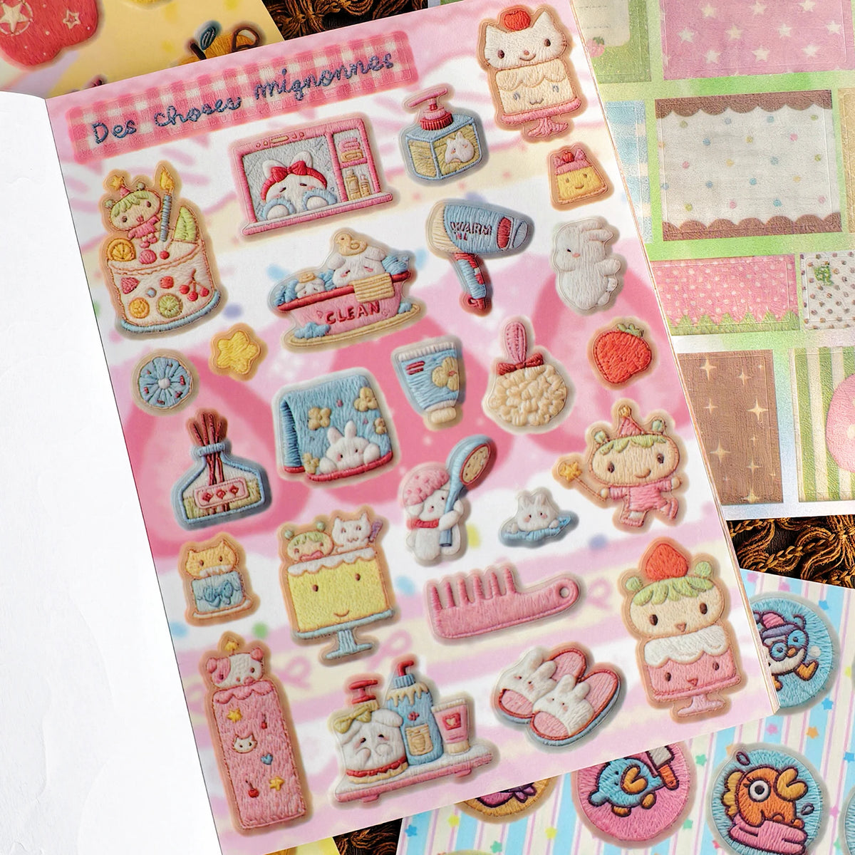 A page from a vintage embroidery sticker book featuring various cute, pastel-colored embroidered stickers for journaling.