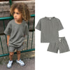 A gray kids summer tracksuit set featuring a short sleeve top and matching shorts displayed on a model.