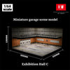 A miniature garage scene model showing an interior view of a display area with brick walls and a concrete floor.