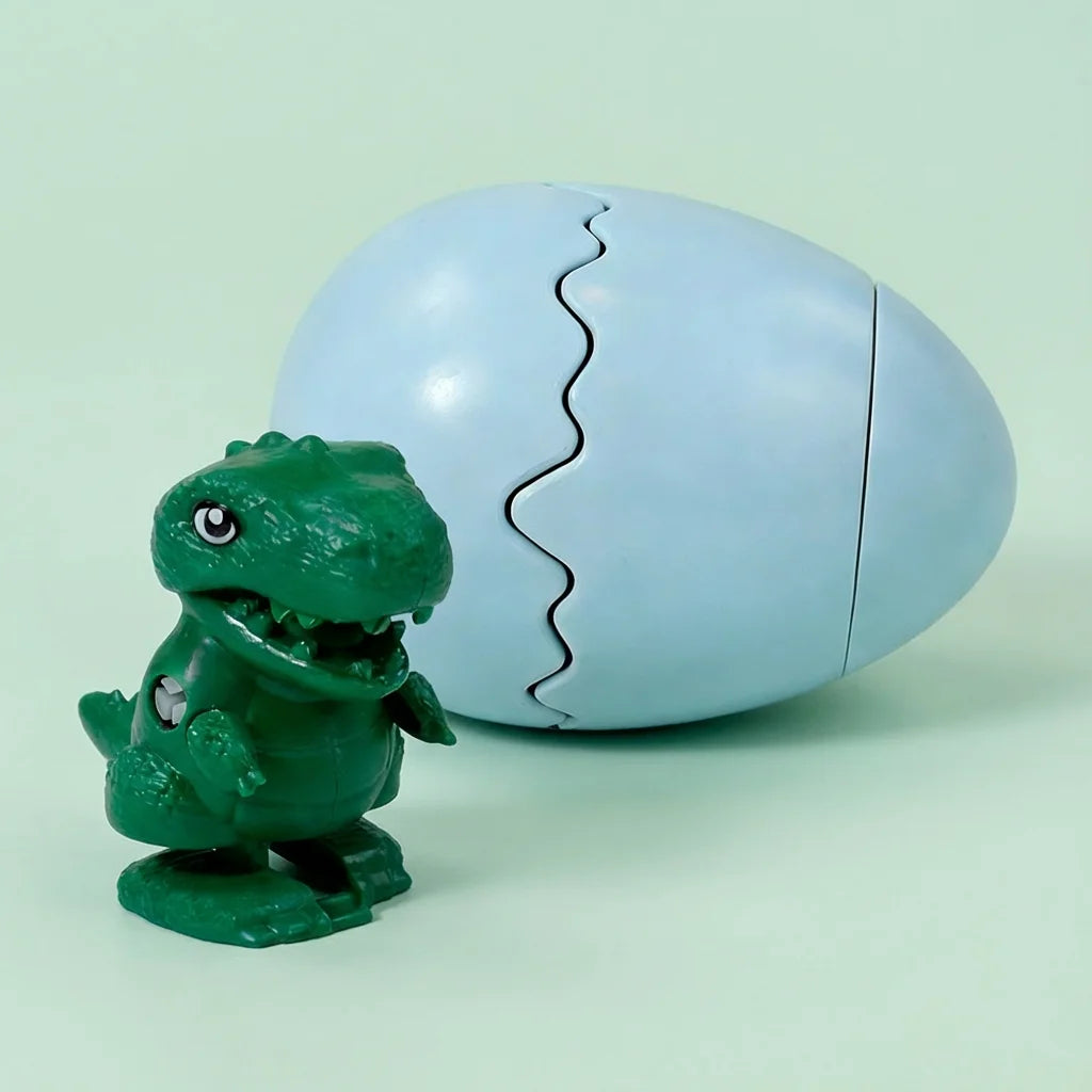 A green wind-up bouncing chick toy is shown cracked open, revealing the interior.
