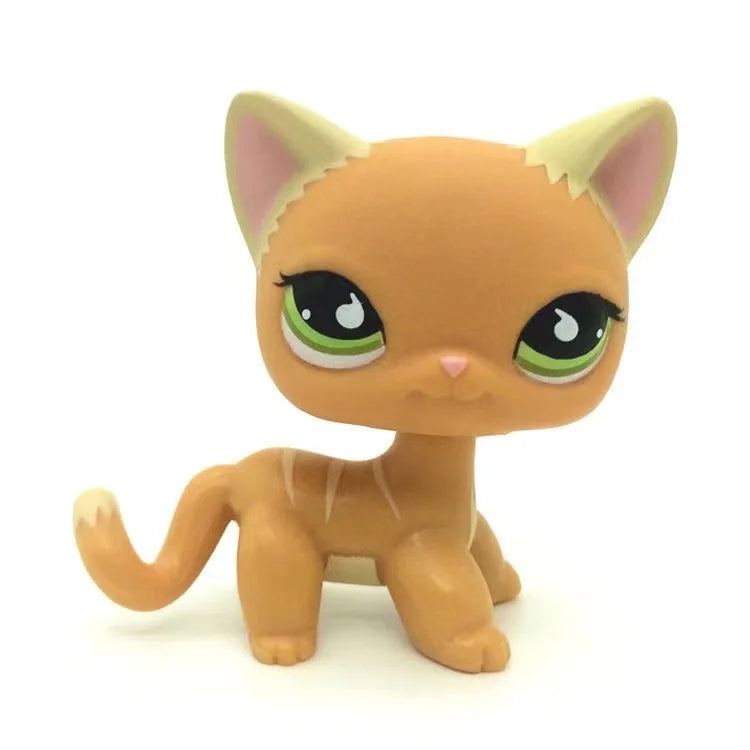 A small, orange and cream-colored Littlest Pet Shop style standing dog figure with large green eyes.