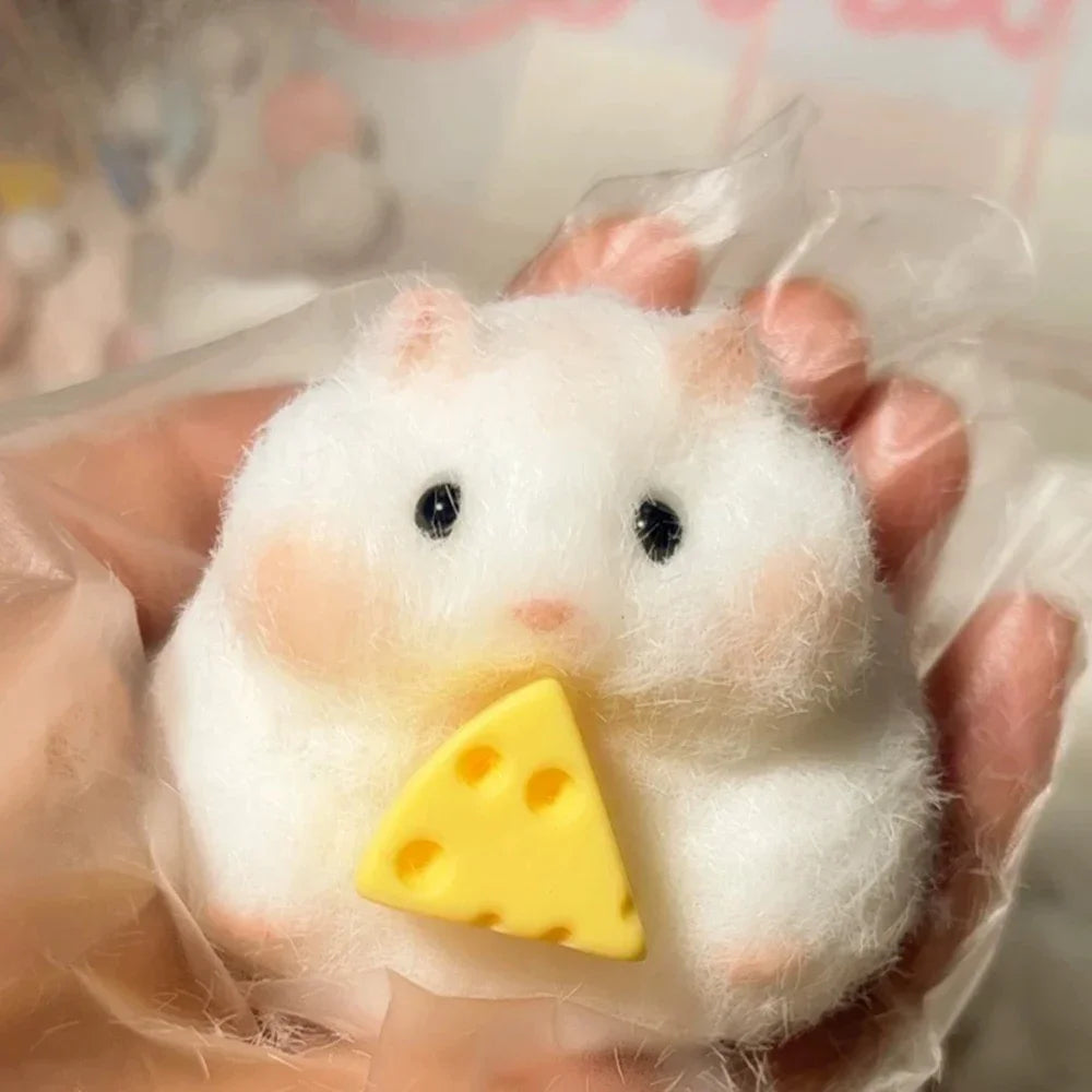 A white squishy silicone hamster fidget toy is held in a hand.