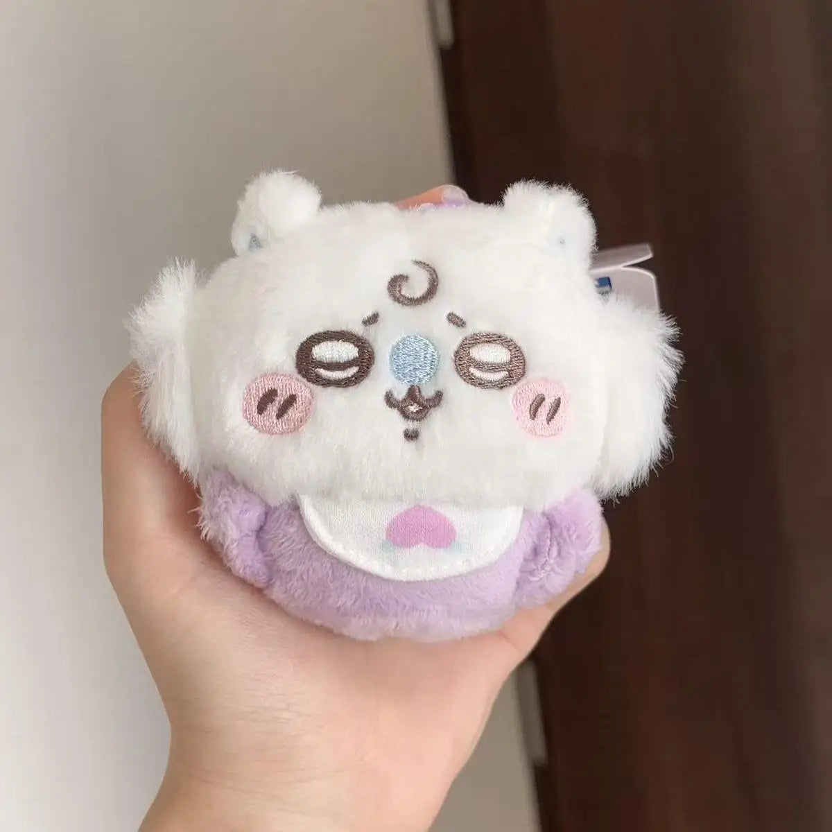 A fluffy white plush keychain set featuring three cute animal characters with pastel accents.