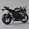 A black Suzuki GSX-R1000R diecast motorcycle model in a studio setting.