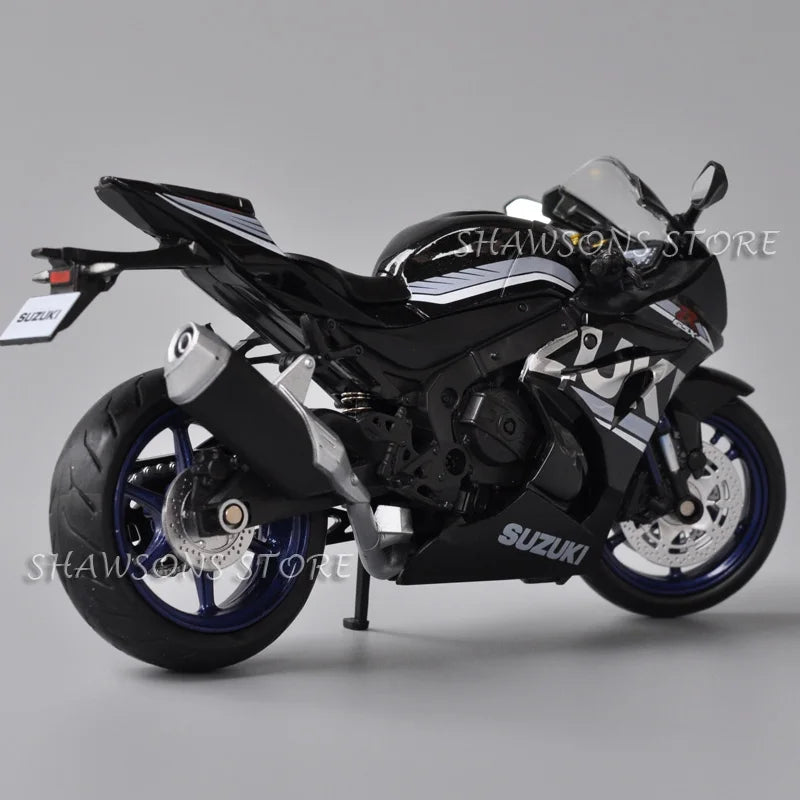 A black Suzuki GSX-R1000R diecast motorcycle model in a studio setting.