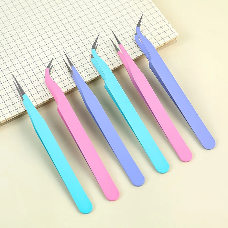 Un jeu de cinq pinces de précision aux couleurs pastel, y compris rose, bleu et violet, posées sur un fond à grille.