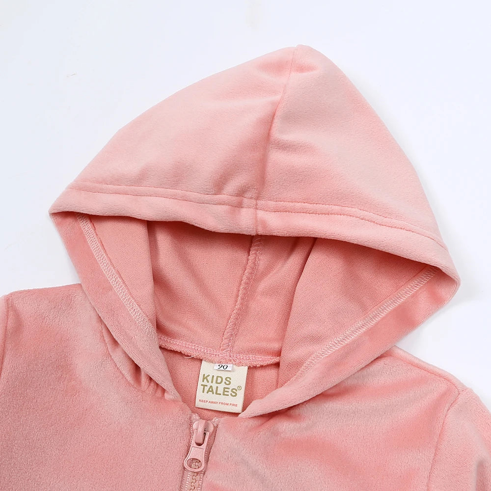 A pink kids velvet tracksuit set featuring a hooded zipper coat and matching pants.