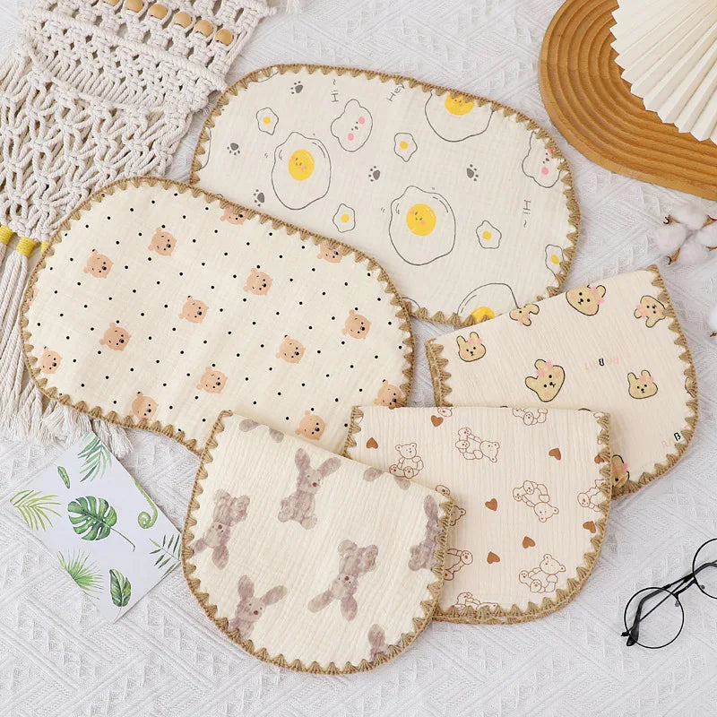 A collection of cute, light-colored fabric pillows featuring various patterns like eggs and animals for newborns.