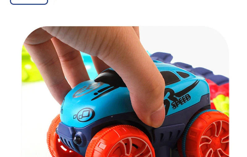 A hand is holding a blue and purple race car track set with orange wheels.