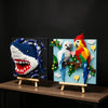 A colorful wall art piece depicting a shark head and a parrot built from 3D building blocks.