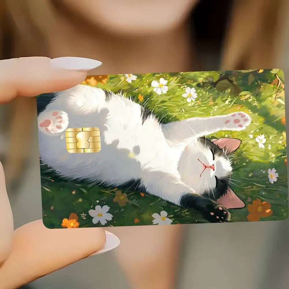 A white and black cat lying on green grass, with a gold-colored paw print visible.