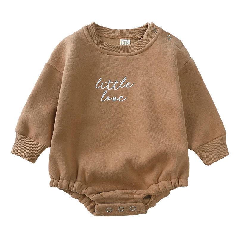 A beige cotton baby romper with the text little love embroidered on the chest.