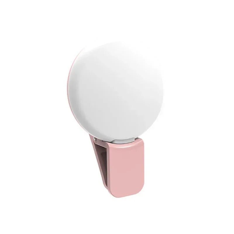 A portable LED selfie ring light in a pink casing with a white light diffuser.