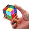 A hand holds a colorful CMY prism cube, showing various vibrant colors and facets.