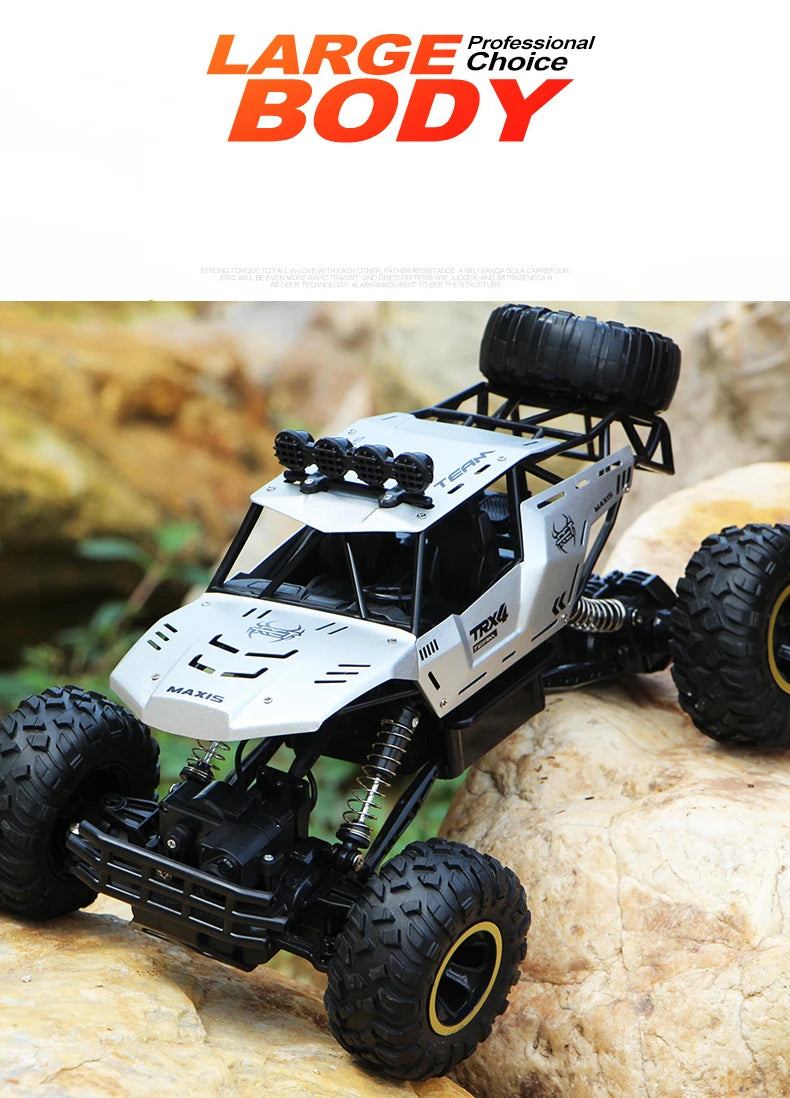 A white and black high-speed 4WD off-road RC truck with large tires is positioned on a light-colored rock.