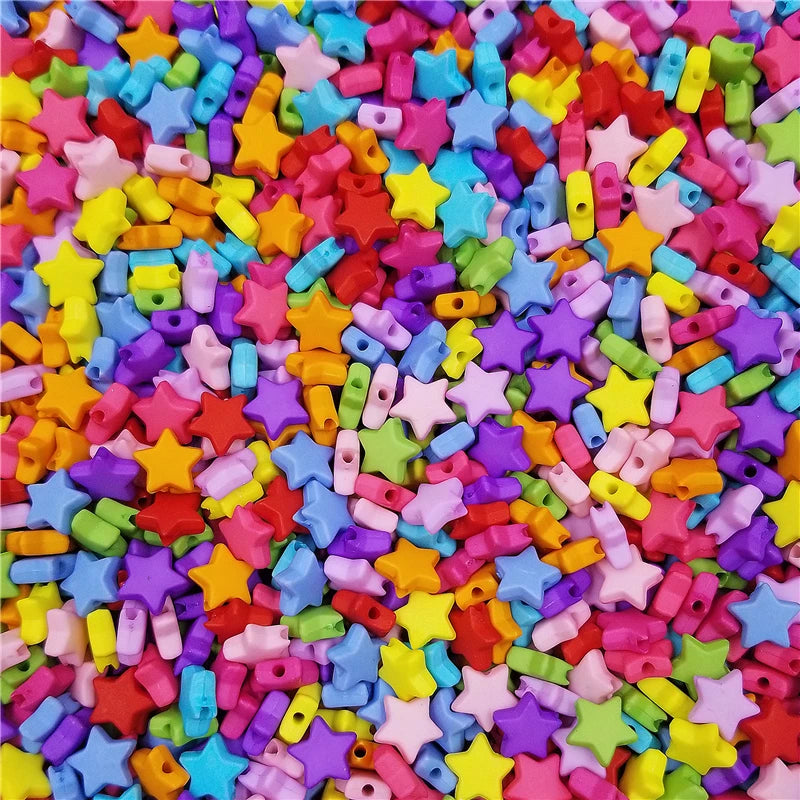 Gros plan d'une pile de perles en forme d'étoiles en acrylique de 9mm de couleurs vives pour la création.