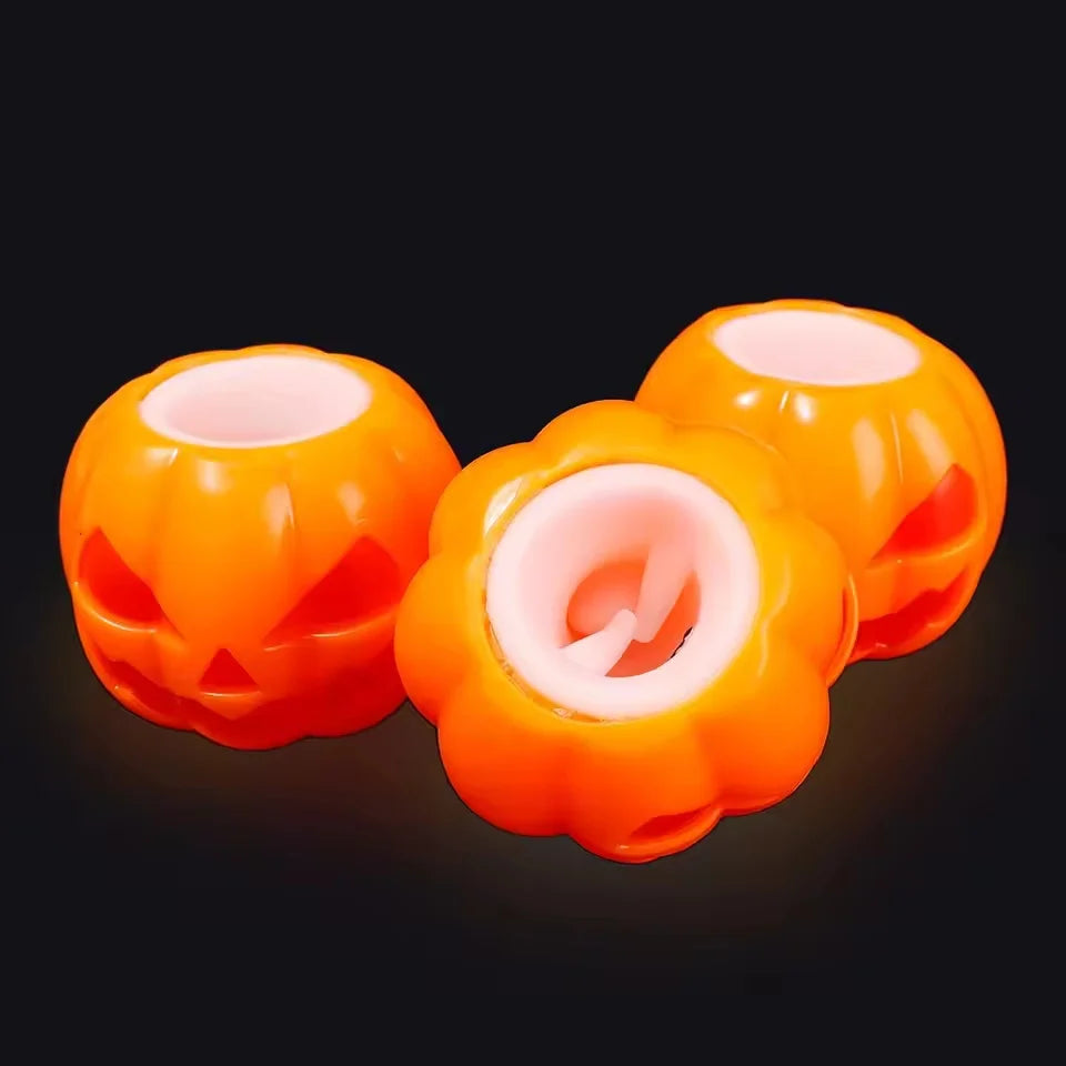 Two bright orange squishy fidget toys shaped like pumpkins with pink interiors