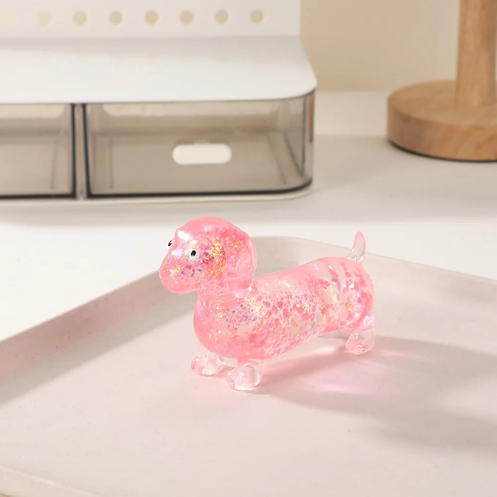 A small, pink, glittery dachshund squishy toy resting on a white plate.