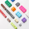 A collection of colorful plastic building blocks in various shapes and colors arranged on a white surface.