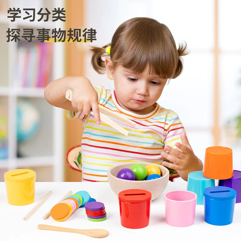 A young child is sorting wooden colored cups and balls into containers on a table.