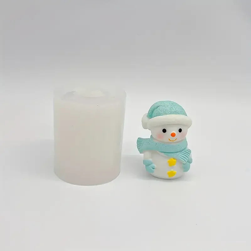 A small, light blue silicone snowman figure with a white hat and scarf is shown next to a white candle.