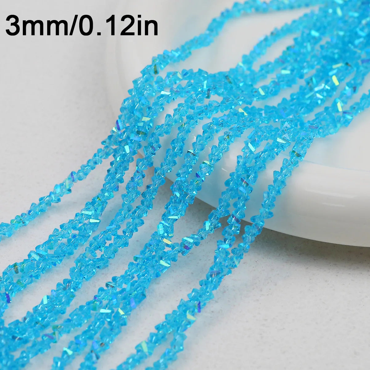 A close-up of bright blue crystal triangle beads strung together for jewelry making.