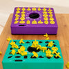 Un plateau de puzzle violet et un jeu de correspondance vert avec des formes 3D jaunes sur une table en bois.