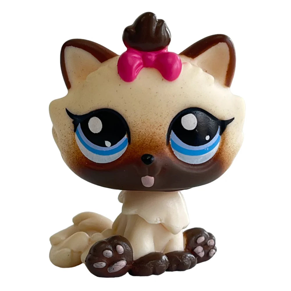 A charming bobble head pet figurine of a cat with large blue eyes and a pink bow.