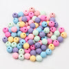 A collection of colorful matte acrylic macarons in various shades of pink, purple, blue, and yellow beads.
