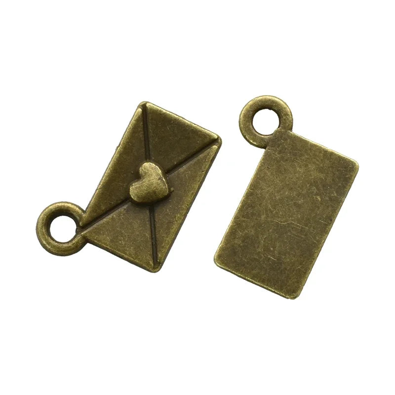 Two antique brass envelope charms with heart accents, used for jewelry making.
