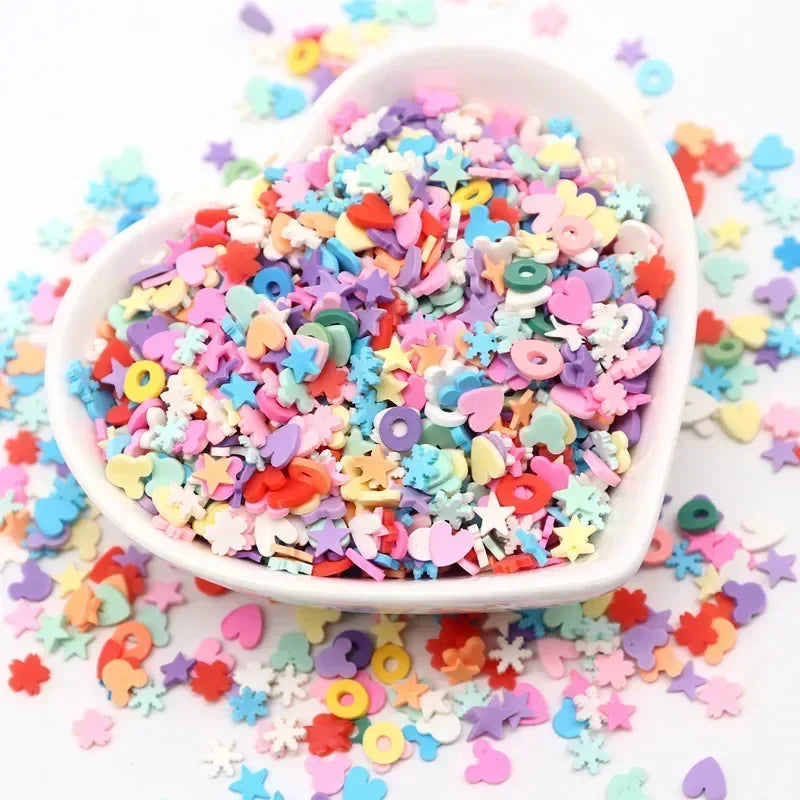 A white bowl filled with colorful polymer clay sprinkles for slime and craft decor scattered on a white surface.