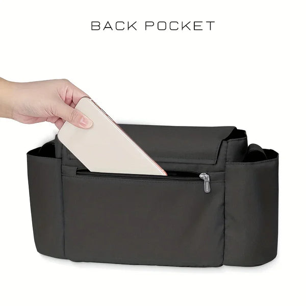 A hand is inserting a card into the back pocket of a dark gray organizer bag.