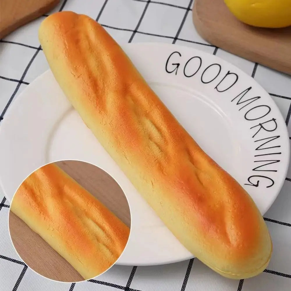 A long, golden loaf of bread is displayed on a white plate with a close-up view of its texture.