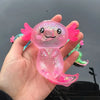 A hand holds a pink squishy axolotl stress relief toy with bright pink fins and glittery skin.