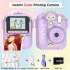 A pink instant color printing camera with a lens, paper, USB cable, and 32GB card visible.