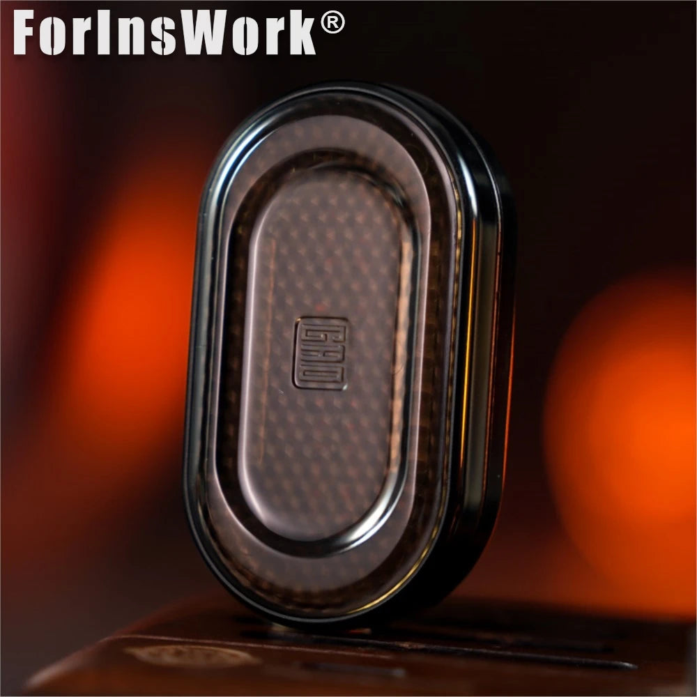 A close-up of a dark brown metal mechanical fidget slider with a gem design on a wooden surface.