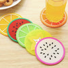 A set of colorful fruit pattern PVC coasters, including orange, watermelon, lime green, and pink slices, are displayed on a w