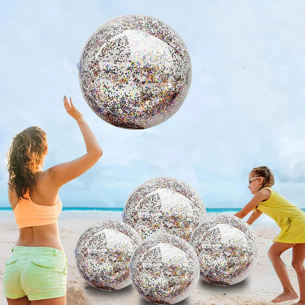 A woman is tossing a large, colorful sequined inflatable beach ball high in the air against a bright sky.