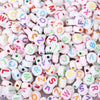A close-up view of small, round acrylic alphabet beads in various colors and letters for jewelry making.