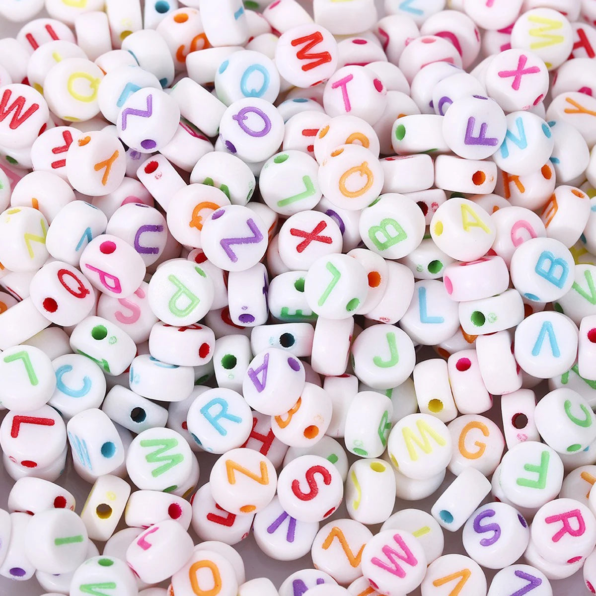 A close-up view of small, round acrylic alphabet beads in various colors and letters for jewelry making.