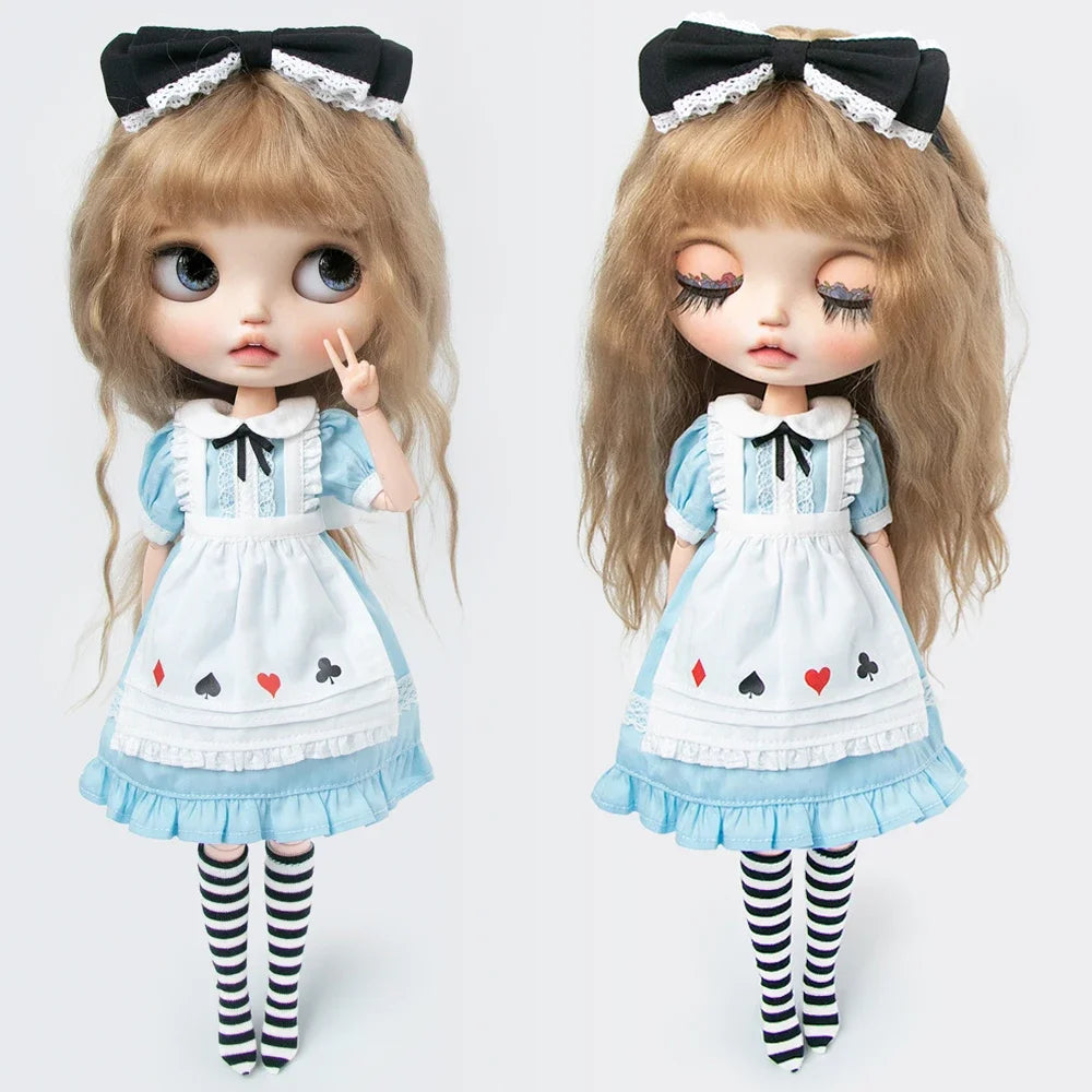 A pair of dolls wearing vintage lace maid dresses with black bows and striped stockings.