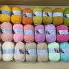 A collection of multicolored soft milk cotton yarn skeins arranged in rows for knitting and crochet projects.