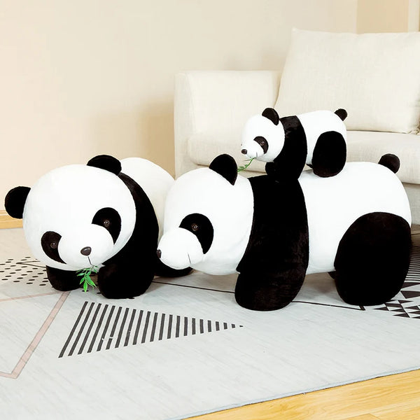 Peluche panda en bambou blanc et noir posée sur un tapis clair.