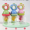 Three silicone dinosaur-shaped feeders in pink, green, and blue for different months of age.
