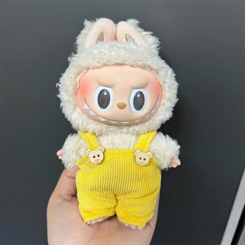 Labubu doll wearing a fluffy cream sweater and yellow knitted overalls