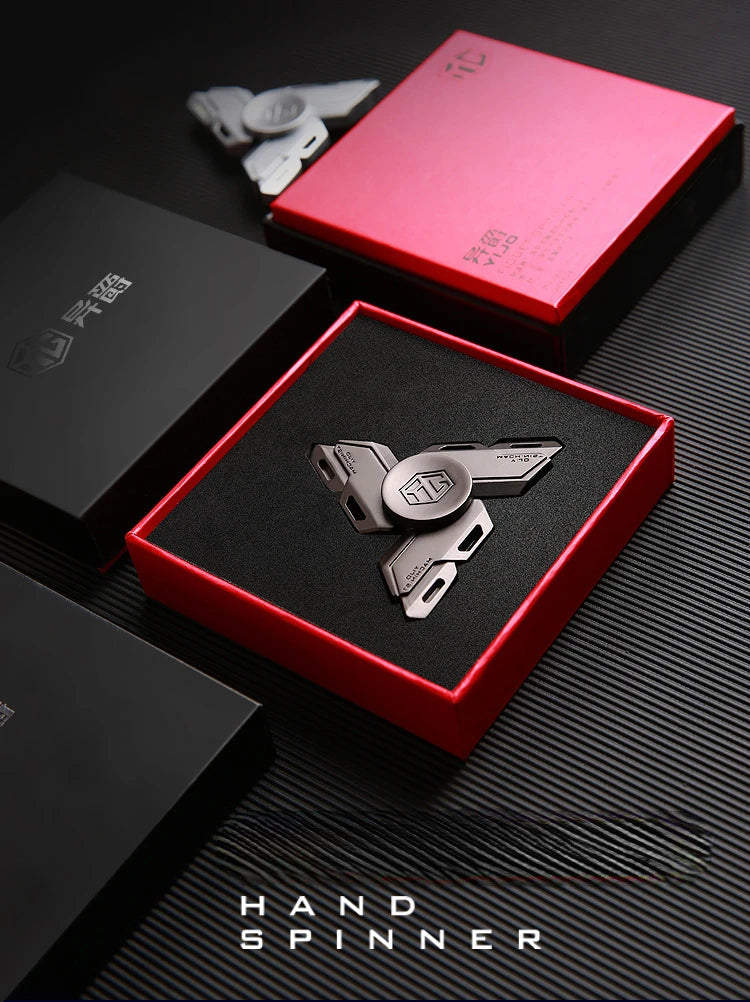 A red box containing a metal luminous fidget spinner is displayed on a dark surface.
